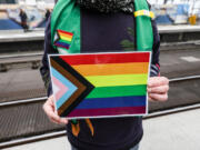 A volunteer holds a "Progress Pride Flag" on March 8 at Hauptbahnhof main railway station in Berlin, Germany.