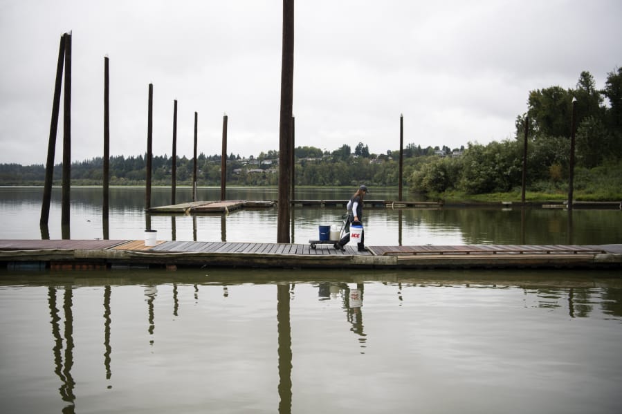 A WSU Vancouver graduate student leaves Vancouver Lake after taking water samples in 2019. Algal blooms in the water have been an issue for years.