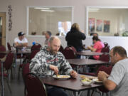 Recovery Cafe Clark County member Chris Mackmer, left, enjoys lunch with volunteer Scott Hacker. Recovery Cafe is a community organization that specializes in helping people with addiction recovery. It is part of a collection of local organizations that have banded together to respond to Clark County's opioid crisis.