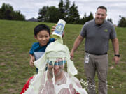 Fifth grader James Saldua, from left, dumps a cup full of homemade slime on his physical education teacher, Devin Cast, as Associate Principal Casey Greco looks on at Felida Elementary School on Monday afternoon. Students and staff were celebrating a successful fundraiser for the American Heart Association's Kids Heart Challenge. James was one of 10 students who raised over $500.