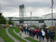 Demonstrators work their way through the pouring rain from Vancouver Waterfront Park to Esther Short Park on Saturday in downtown Vancouver.