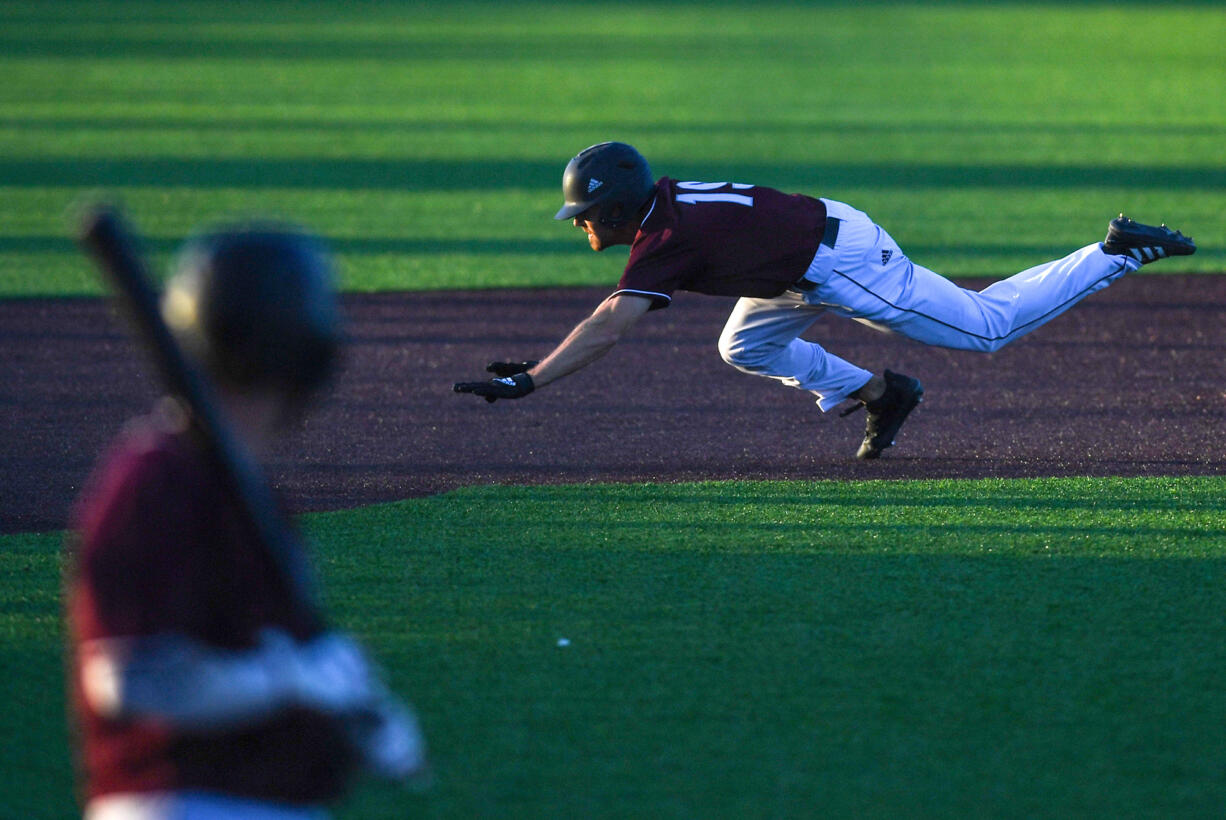 Raptors center fielder Austin Caviness dives for third base Friday, June 24, 2022, during a game between Ridgefield and the Victoria HarbourCats at the Ridgefield Outdoor Recreation Complex.