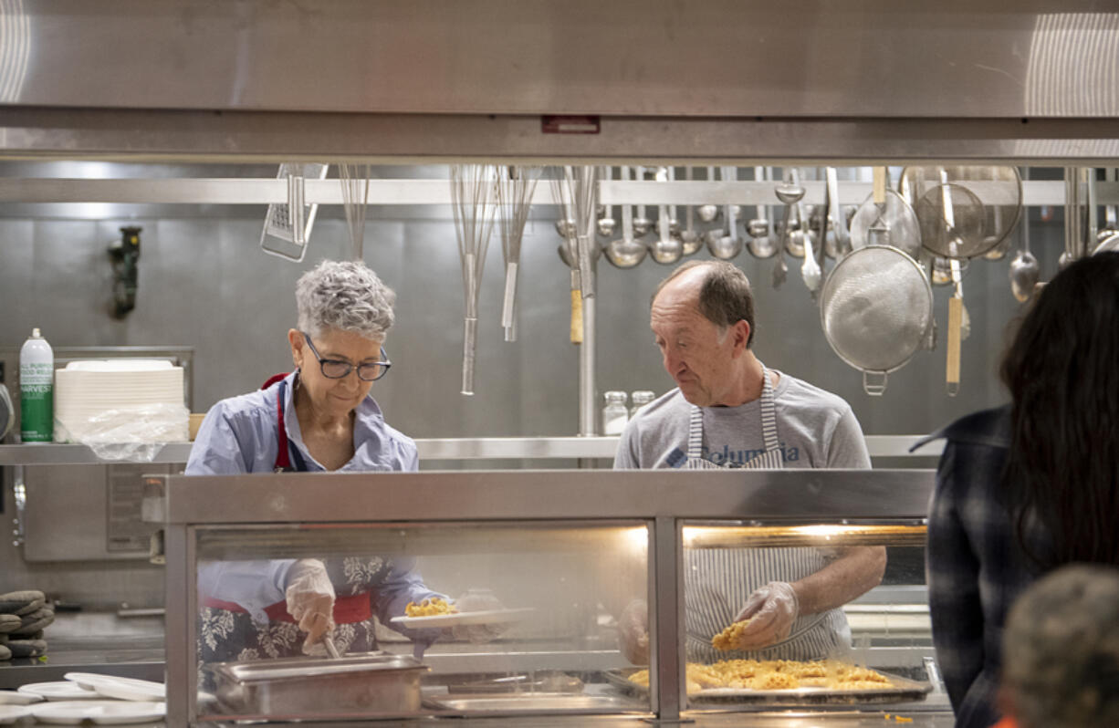 Volunteers Susan and Phil Harding serve eggs, waffles and sausages to participants in the Hot Meals program at the Share House on Tuesday morning. Before the COVID-19 pandemic, the program served roughly 3,000 meals a month. Now, it serves about 9,000 meals a month, and more volunteers are needed to keep up. "Share says all the time that they couldn't do it without volunteers," Phil Harding said.