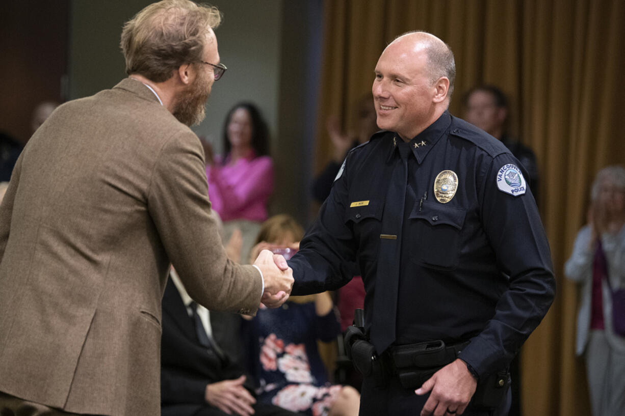 Vancouver City Attorney Jonathan Young, left, congratulates Jeffrey Mori after he took the oath of office to become the new chief of the Vancouver Police Department on Thursday evening at Vancouver City Hall. Mori has 29 years of law enforcement experience, including nine years as the undersheriff at the Washington County Sheriff's Office in Oregon.