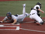 Auburn's Cole Foster slides past Oregon State's Gavin Logan to score during the third inning of an NCAA college baseball tournament super regional game Saturday, June 11, 2022, in Corvallis, Ore.