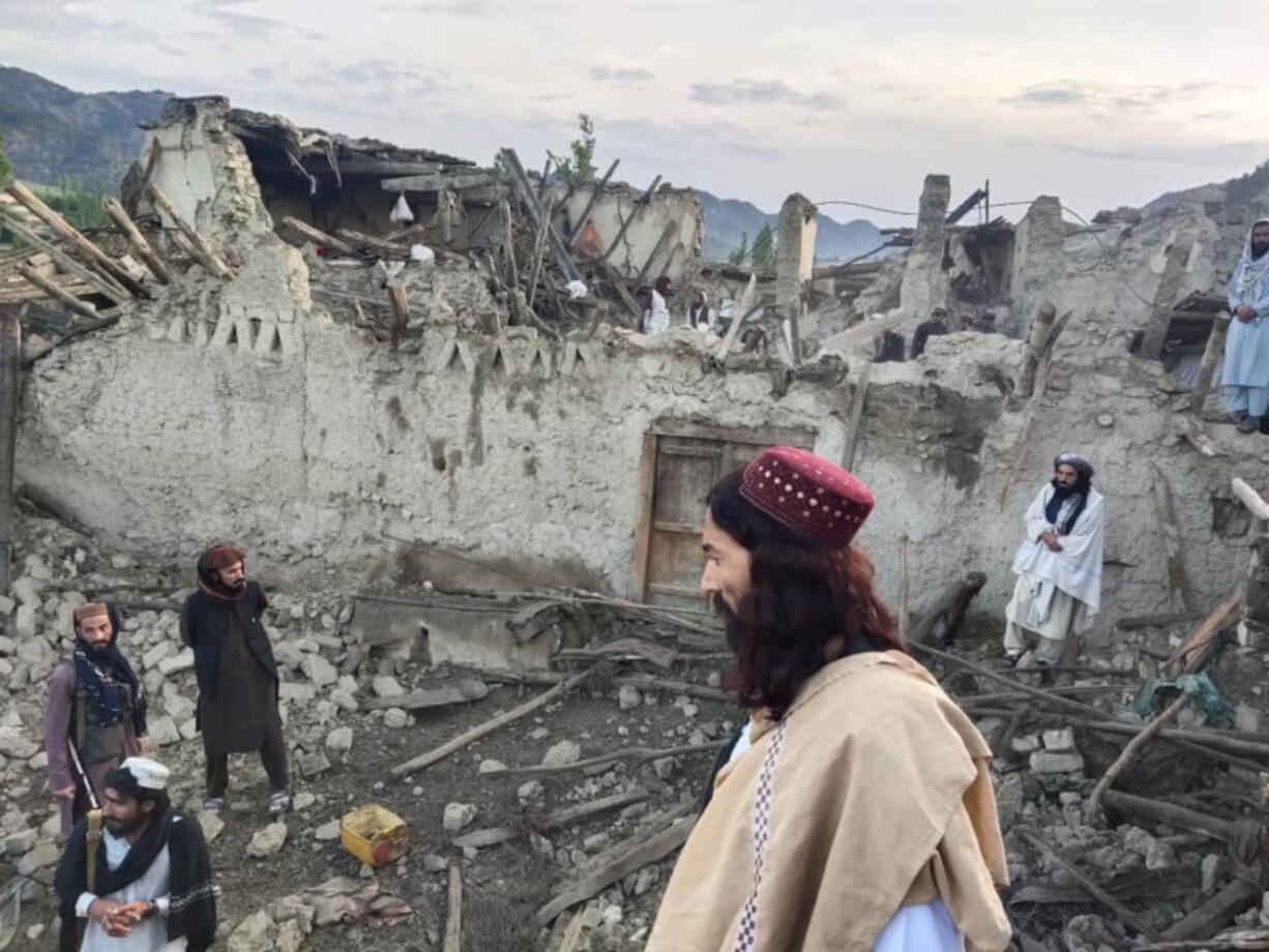 In this photo released by a state-run news agency Bakhtar, Afghans look at destruction caused by an earthquake in the province of Paktika, eastern Afghanistan, Wednesday, June 22, 2022.