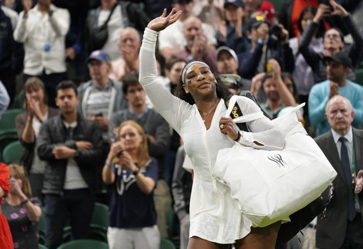 Serena Williams of the US waves as she leaves the court after losing to France's Harmony Tan in a first round women's singles match on day two of the Wimbledon tennis championships in London, Tuesday, June 28, 2022.