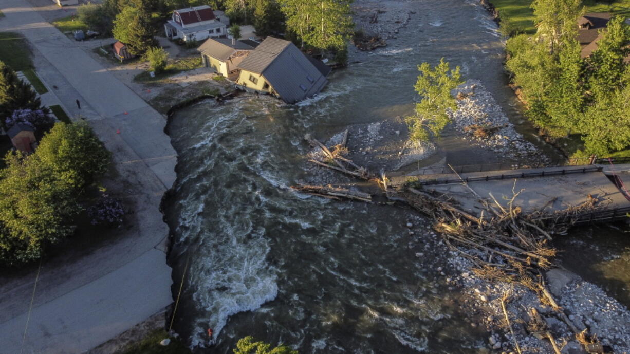 A house sits in Rock Creek after floodwaters washed away a road and a bridge in Red Lodge, Mont., Wednesday, June 15, 2022.