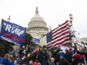 FILE - Rioters stand outside the U.S. Capitol in Washington, on Jan. 6, 2021.  A new poll shows that about half of Americans say former President Donald Trump should be charged with a crime for his role in what happened on Jan. 6. The Associated Press-NORC Center for Public Affairs Research poll found that 48% of U.S.