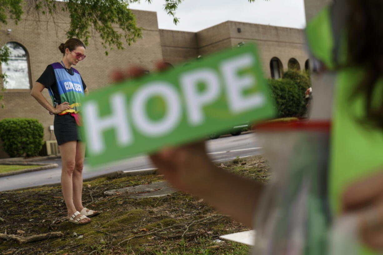 Planned Parenthood advocacy programs manager, Allison Terracio, left, stands outside the clinic to escort patients showing up for abortion appointments as Valerie Berry, program manager for the anti-abortion group, A Moment of Hope, holds up a sign at the entrance in Columbia, S.C., Friday, May 27, 2022. After decades of tiny steps and endless setbacks, America's anti-abortion movement is poised for the possibility of a massive leap. With the Supreme Court due to deliver a landmark ruling expected to seriously curtail or completely overturn the constitutional right to abortion found in the 49-year-old Roe v. Wade decision, anti-abortion advocates across the U.S. are hopeful they'll be recording a win.