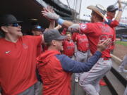 Los Angeles Angels' Mike Trout, right, is greeted in the dugout after hitting a two-run home run on a pitch from Seattle Mariners starting pitcher Logan Gilbert during the fourth inning of a baseball game, Sunday, June 19, 2022, in Seattle.