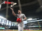 Los Angeles Angels' Mike Trout reaches for a cowboy hat as he walks to the dugout after hitting a solo home run against the Seattle Mariners during the third inning of the second baseball game of a doubleheader Saturday, June 18, 2022, in Seattle. (AP Photo/Ted S.