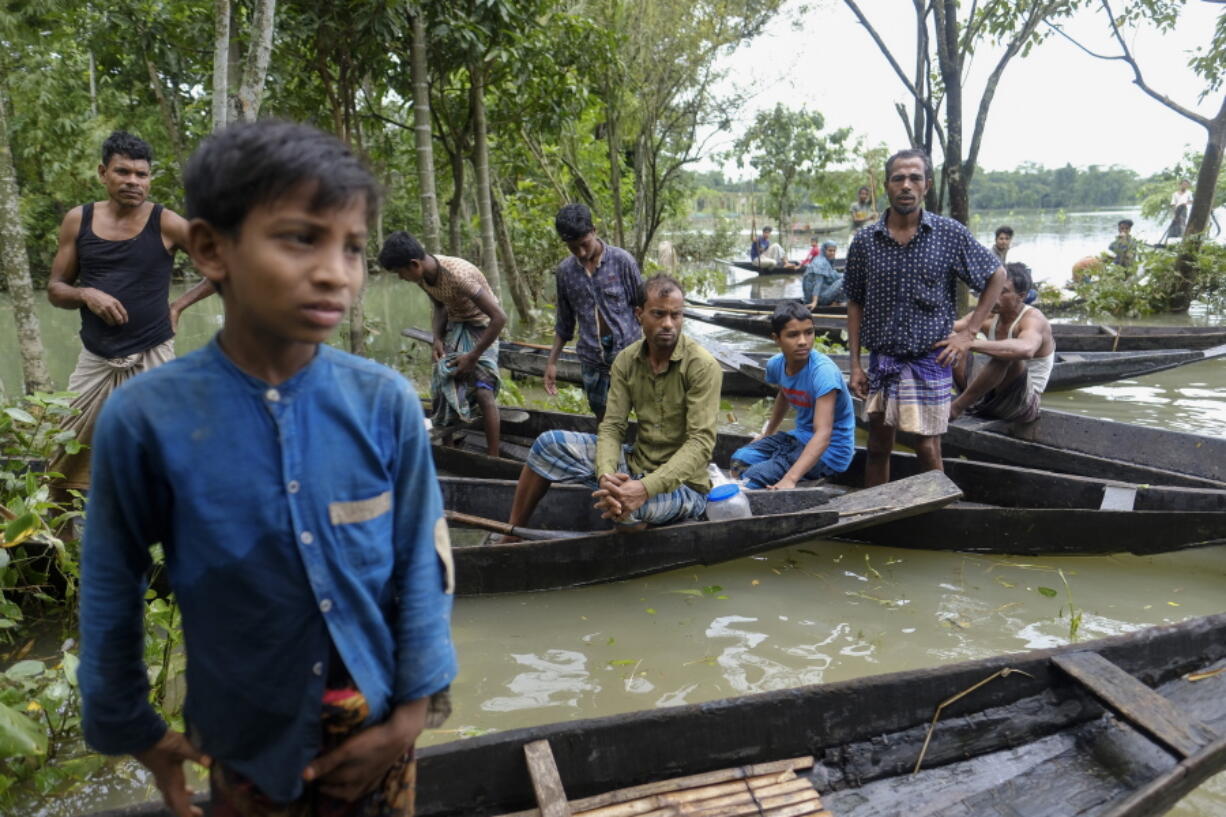 Flood affected people wait to receive relief material in Sylhet, Bangladesh, Wednesday, June 22, 2022.