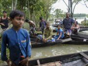 Flood affected people wait to receive relief material in Sylhet, Bangladesh, Wednesday, June 22, 2022.