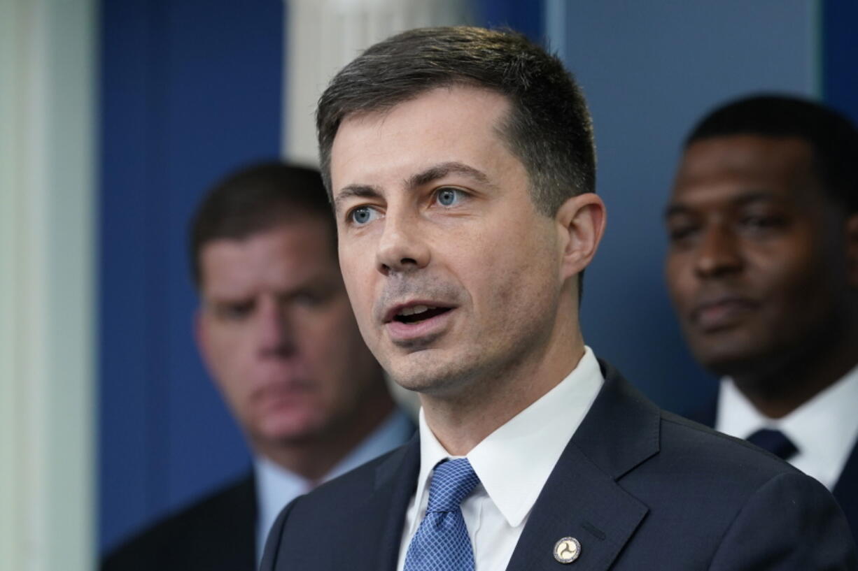 FILE - Transportation Secretary Pete Buttigieg, center, speaks during a briefing at the White House in Washington, May 16, 2022, as Labor Secretary Marty Walsh, left, and Environmental Protection Agency administrator Michael Regan, right, listen. Buttigieg says he is pushing airlines to hire more customer-service people and take other steps to help travelers this summer.