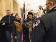 FILE - Kevin Seefried, second from left, holds a Confederate battle flag as he and other insurrectionists loyal to President Donald Trump are confronted by U.S. Capitol Police officers outside the Senate Chamber inside the Capitol in Washington, Jan. 6, 2021. A federal judge on Wednesday, June 15, 2022, convicted Kevin Seefried and his adult son Hunter Seefried of charges that they stormed the U.S. Capitol together to obstruct Congress from certifying President Joe Biden's 2020 electoral victory.