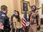 FILE - In this Wednesday, Jan. 6, 2021 file photo, supporters of President Donald Trump, including Jacob Chansley, right with fur hat, are confronted by U.S. Capitol Police officers outside the Senate Chamber inside the Capitol in Washington. More than 800 people across the U.S. have been charged in the Jan. 6 riot at the Capitol that left officers bloodied and sent lawmakers running in fear, and federal authorities continue to make new arrests practically every week.