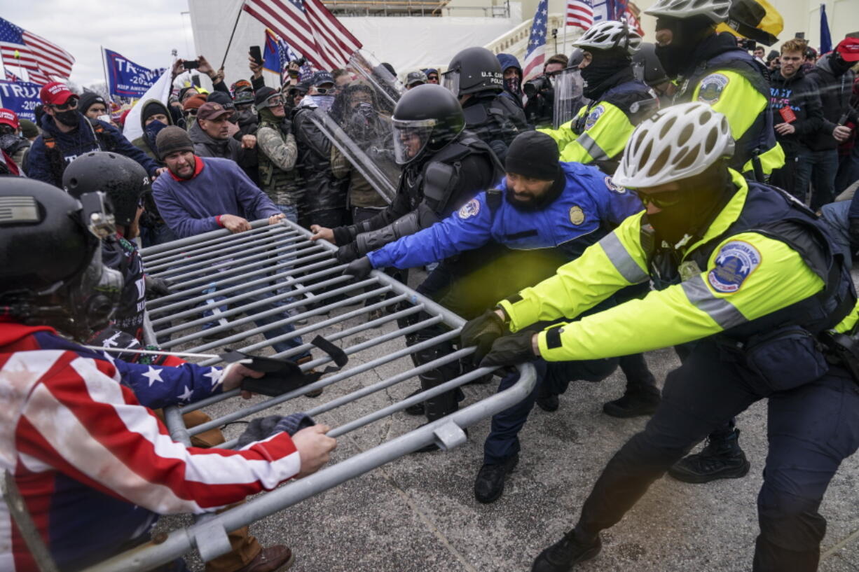 FILE - Rioters try to break through a police barrier at the Capitol in Washington on Jan. 6, 2021. Members of the House committee investigating the events of Jan. 6 will hold their first prime time hearing Thursday, June 9, 2022, to share what they have uncovered.