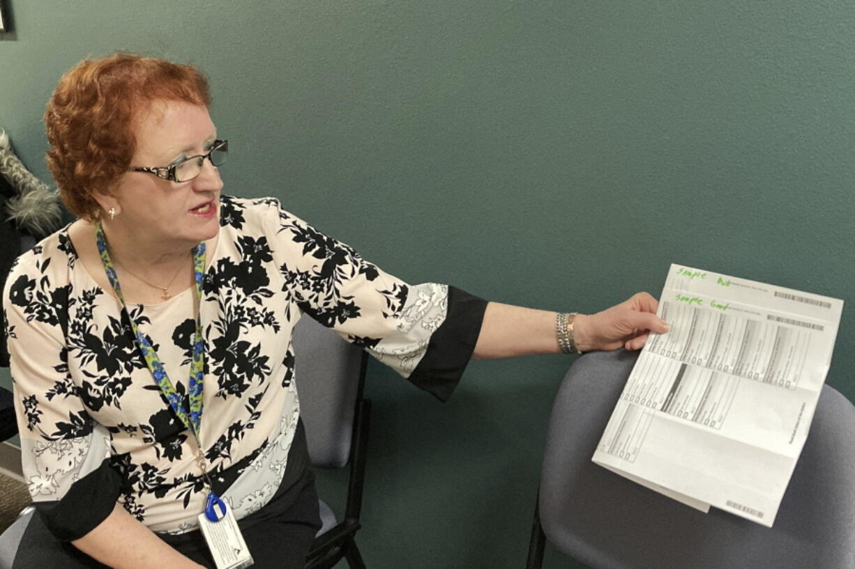 Clackamas County Elections Clerk Sherry Hall shows sample ballots at the Clackamas County Elections office on Thursday, May 19, 2022, Oregon City, Ore. Ballots with blurry barcodes that can't be read by vote-counting machines will delay election results by weeks in a key U.S. House race in Oregon's primary. Hall said the problem first came to light May 3, when elections workers put the first ballots returned in the vote-by-mail state through the vote-counting machine.