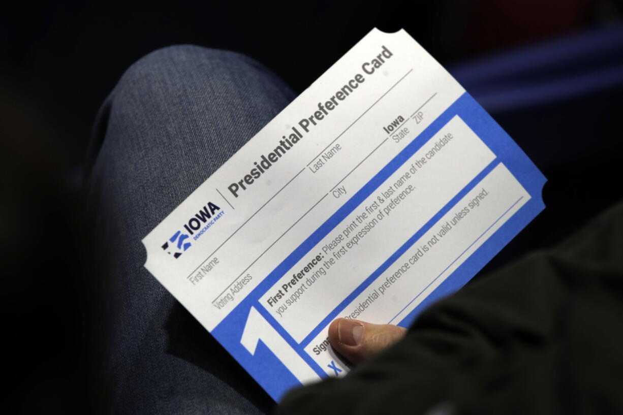 FILE - A Precinct 68 Iowa Caucus voter holds a presidential preference card as the night of caucusing gets underway at the Knapp Center on the Drake University campus in Des Moines, Iowa, Feb. 3, 2020. Iowa Democrats are proposing two key changes that they hope will increase participation and avoid the chaos that marred their 2020 caucuses. One change would allow Iowa Democrats to submit presidential preference cards by mail or in person before caucus night. (AP Photo/Gene J.