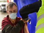 FILE - Crager Boardman, from Brattleboro, Vt., receives a shot at a flu vaccine clinic in Brattleboro on Tuesday, Oct. 26, 2021. On Wednesday, June 22, 2022, a federal advisory panel says Americans 65 and older should get newer, souped-up flu vaccines. The panel unanimously recommended certain flu vaccines for seniors, whose weakened immune systems don't respond as well to traditional shots.