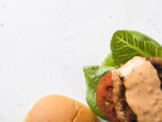 This image released by Milk Street shows a recipe for Smoky Chili-Garlic Pork Burgers.