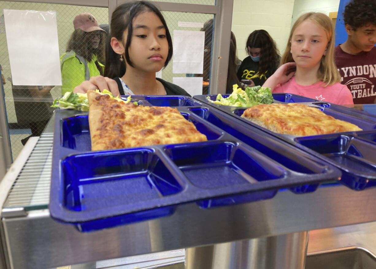 Students get lunch of homemade pizza and caesar salad at the Albert D. Lawton Intermediate School, in Essex Junction, Vt., Thursday, June 9, 2022. The pandemic-era federal aid that made school meals available for free to all public school students -- regardless of family income levels -- is ending, raising fears about the effects in the upcoming school year for families already struggling with rising food and fuel costs.