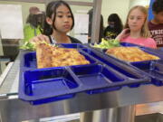 Students get lunch of homemade pizza and caesar salad at the Albert D. Lawton Intermediate School, in Essex Junction, Vt., Thursday, June 9, 2022. The pandemic-era federal aid that made school meals available for free to all public school students -- regardless of family income levels -- is ending, raising fears about the effects in the upcoming school year for families already struggling with rising food and fuel costs.