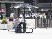 A person sits at a table at Daley Plaza in the loop, Monday, June 13, 2022, in Chicago.