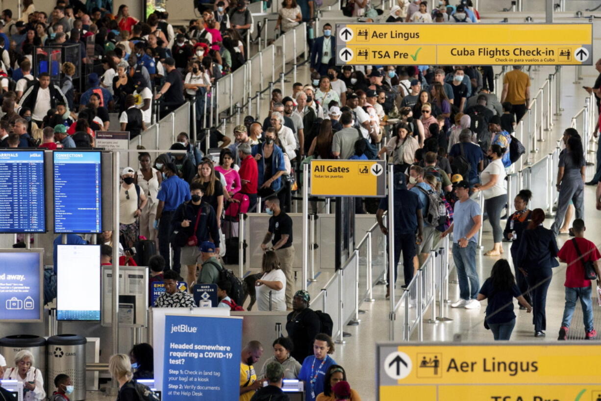 People wait in a TSA line at the John F. Kennedy International Airport on Tuesday, June 28, 2022, in New York.