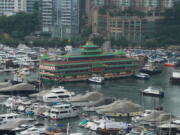 Hong Kong's iconic Jumbo Floating Restaurant is towed away in Hong Kong, Tuesday, June 14, 2022. Hong Kong's iconic restaurant on Tuesday departed the city, after its parent company failed to find a new owner and lacked funds to maintain the establishment amid months of COVID-19 restrictions.