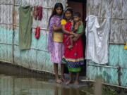 A flood affected family waits for the help at marooned Tarabari village, west of Gauhati, in the northeastern Indian state of Assam, Monday, June 20, 2022. Authorities in India and Bangladesh are struggling to deliver food and drinking water to hundreds of thousands of people evacuated from their homes in days of flooding that have submerged wide swaths of the countries. The floods triggered by monsoon rains have killed more than a dozen people, marooned millions and flooded millions of houses.