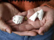 Christina Taylor holds plaster casts of her baby's hands and feet at her home in Littleton, Colo., on Wednesday, April 27, 2022. Taylor chose to get an abortion when she found out after 20 weeks that her baby had no kidneys or bladder. Taylor said she honors her loss with the casts, which were made by the hospital's bereavement team.