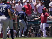 Seattle Mariners' Jesse Winker (27) gets set to fight with Los Angeles Angels Anthony Rendon after he was hit by a pitch and went after players in the Angels dugout during the second inning of a baseball game Sunday, June 26, 2022, in Anaheim, Calif. (AP Photo/Mark J.