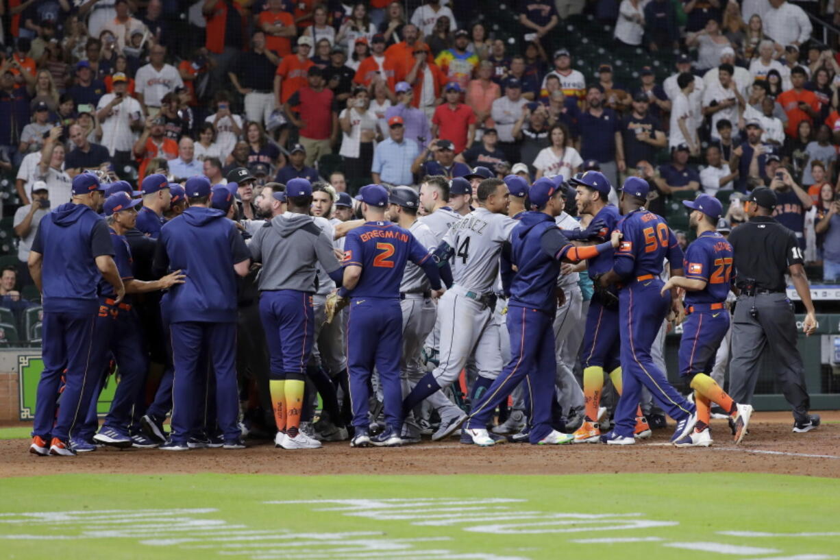 Both dugouts empty and umpires try to keep order after Seattle Mariners batter Ty France was hit by a pitch from Houston Astros relief pitcher Hector Neris during the ninth inning of a baseball game Monday, June 6, 2022, in Houston.