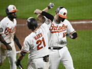 Baltimore Orioles' Trey Mancini, right, celebrates his two-run home run with Austin Hays (21) and Cedric Mullins, left, during the sixth inning of the team's baseball game against the Seattle Mariners, Wednesday, June 1, 2022, in Baltimore.