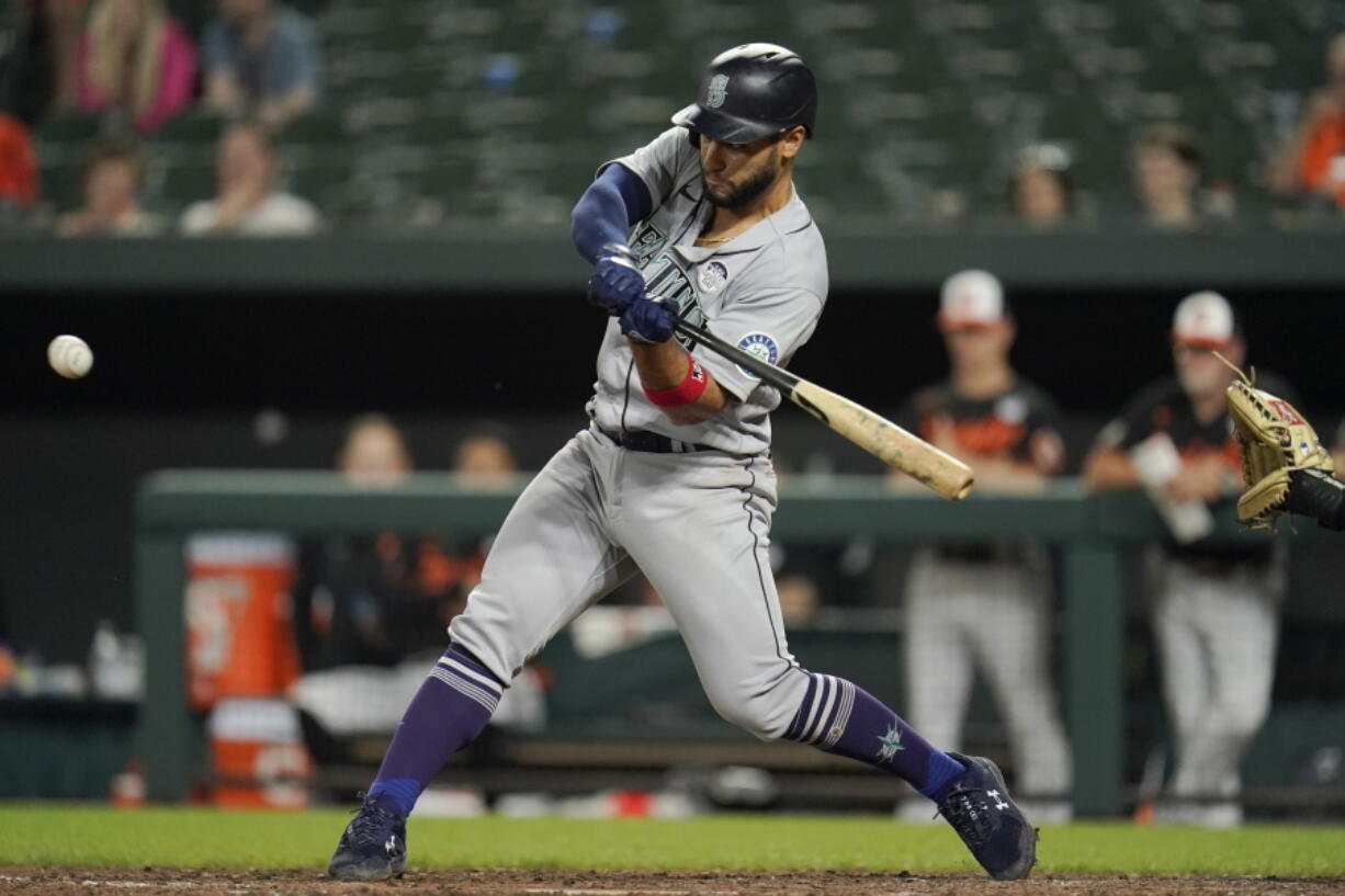 Seattle Mariners' Abraham Toro swings at a pitch while hitting a triple to bring in Eugenio Suarez with a run during the 10th inning of a baseball game against the Baltimore Orioles, Thursday, June 2, 2022, in Baltimore. The Mariners won 7-6 in ten innings.