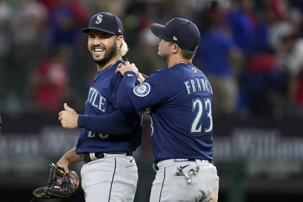 Seattle Mariners' Eugenio Suarez, left, and Ty France (23) celebrate their win in a baseball game against the Texas Rangers, Friday, June 3, 2022, in Arlington, Texas.