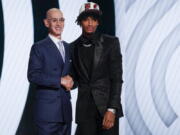 Shaedon Sharpe, right, shakes hands with NBA Commissioner Adam Silver after being selected seventh overall by the Portland Trailblazers in the NBA basketball draft, Thursday, June 23, 2022, in New York.