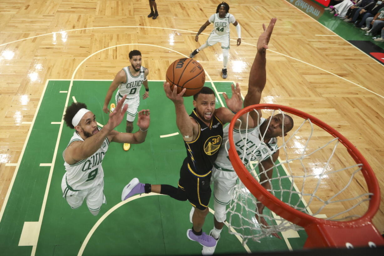 Golden State Warriors guard Stephen Curry (30) goes up for a shot against Boston Celtics center Al Horford (42) and guard Derrick White (9) during Game 4 of basketball's NBA Finals, Friday, June 10, 2022, in Boston.