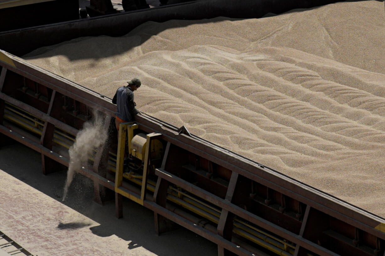 An employee of the Romanian grain handling operator Comvex oversees the unloading of Ukrainian cereals from a barge in the Black Sea port of Constanta, Romania, Tuesday, June 21, 2022. While Romania has vocally embraced the ambitious goal of turning into a main hub for the export of agricultural products from Ukraine, economic experts and port operators in the country warn that it was much easier objective to set than to actually achieve.