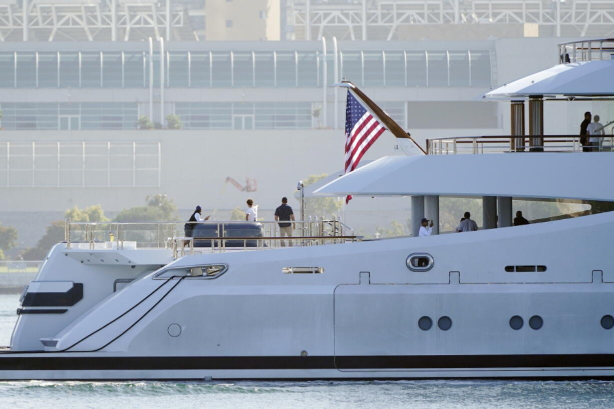 FILE - People look on from the super yacht Amadea as it arrives to the San Diego Bay Monday, June 27, 2022, seen from Coronado, Calif. The $325 million superyacht seized by the United States from a sanctioned Russian oligarch arrived in San Diego Bay on Monday. A multinational task force designed to seize Russian oligarchs' wealth has blocked and frozen $30 billion in sanctioned individuals' property and funds in its first 100 days.