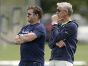 Seattle Seahawks general manager John Schneider, left, and coach Pete Carroll watch NFL football practice Wednesday, June 8, 2022, in Renton, Wash. (AP Photo/Ted S.