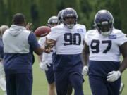 Seattle Seahawks defensive tackles Bryan Mone (90) and Poona Ford (97) run a drill during NFL football practice Wednesday, June 8, 2022, in Renton, Wash. (AP Photo/Ted S.