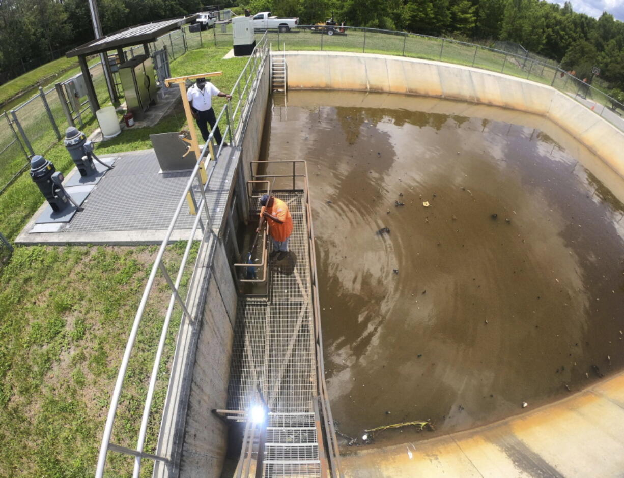 Orange County Public Workers pump station manager Reginald Peoples clears a storm drainage grate of debris at Bonnie Brook in Orlando, Fla., with foreman Lee Owens, left, Thursday, June 2, 2022, as Central Florida readies for the possibility of heavy rainfall from the Gulf of Mexico this weekend following the remnants of Hurricane Agatha that hit southern Mexico on Monday.