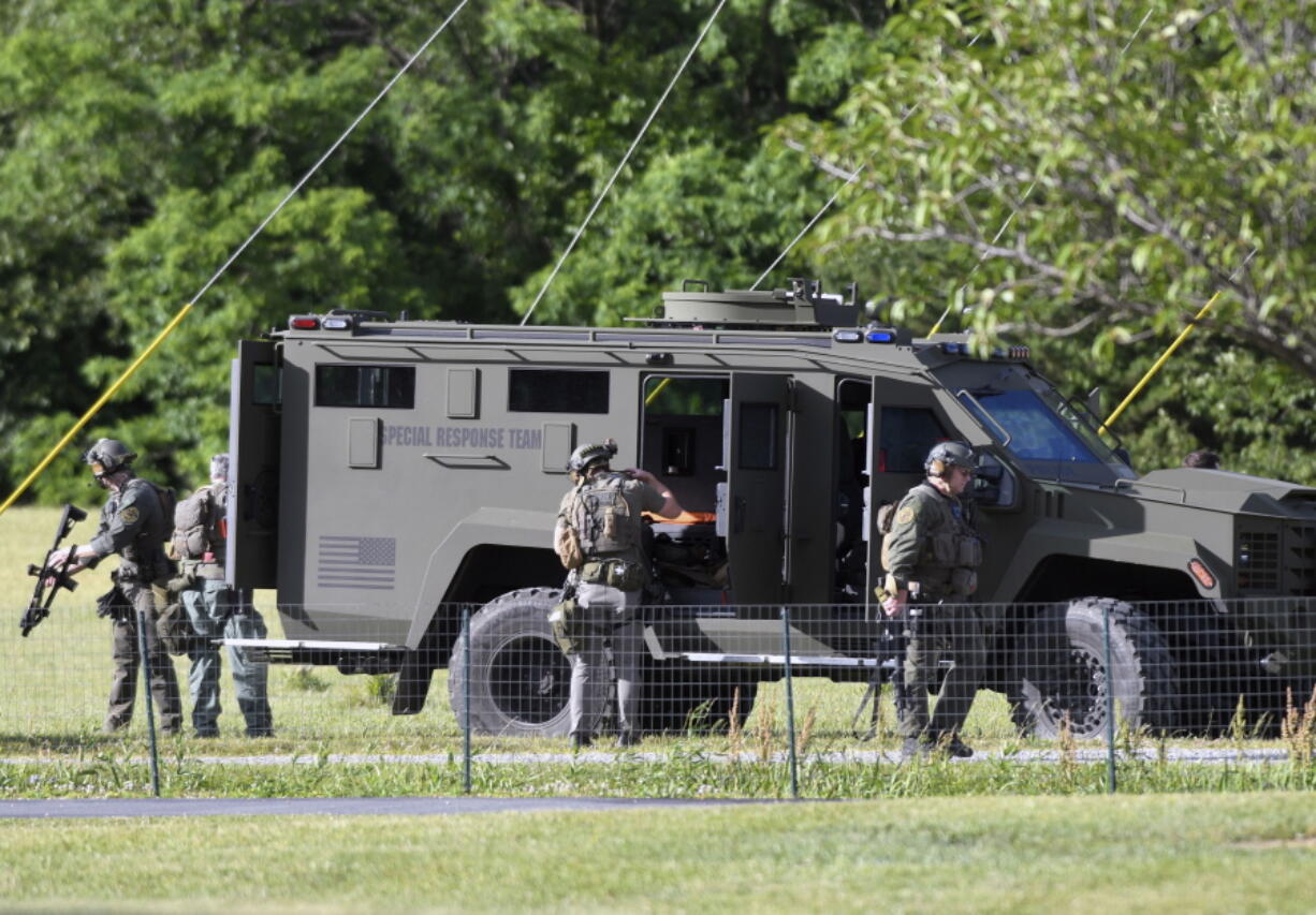 Tactical police work near where a man opened fire at a business, killing three people before the suspect and a state trooper were wounded in a shootout, according to authorities, in Smithsburg, Md., Thursday, June 9, 2022. The Washington County (Md.) Sheriff's Office said in a news release that three victims were found dead at Columbia Machine Inc. and a fourth victim was critically injured.