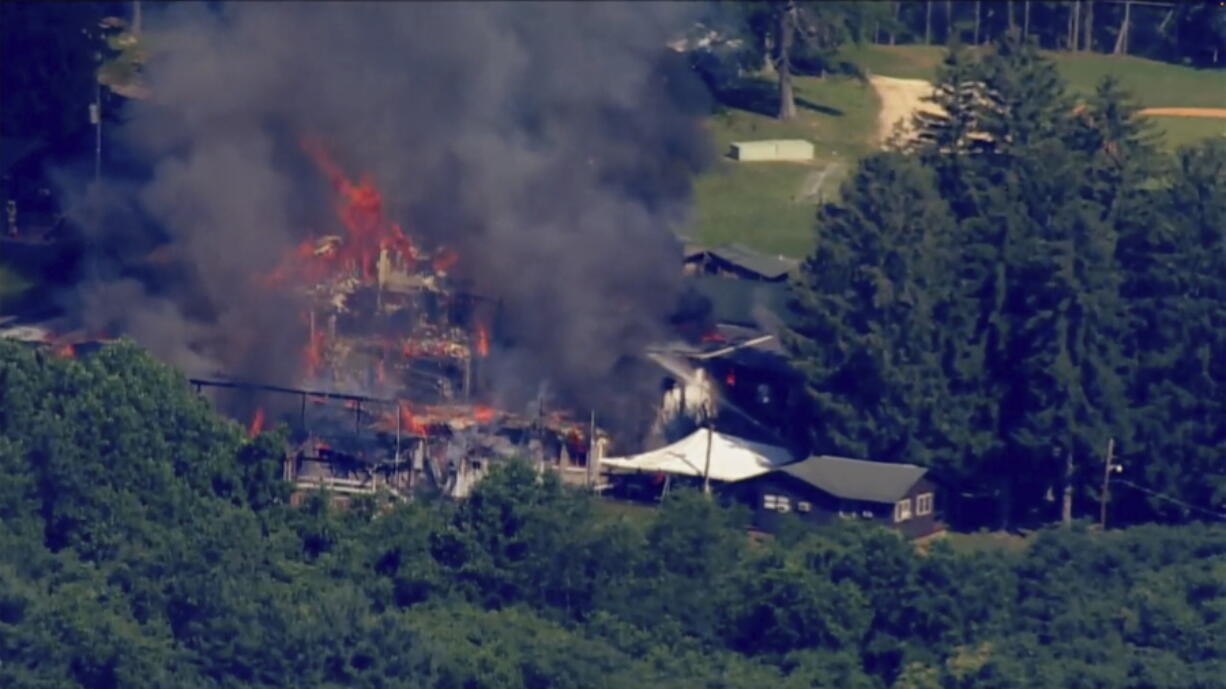 This image taken from video provided by WJLA shows crews battling a fire at Camp Airy for Boys in Thurmont, Md., on Wednesday, June 29, 2022. The building was empty when the fire broke out and no injuries have been reported, Frederick County Division of Fire & Rescue Services spokesperson Sarah Campbell said.  Residents and campers were not in the area of the fire, she said.