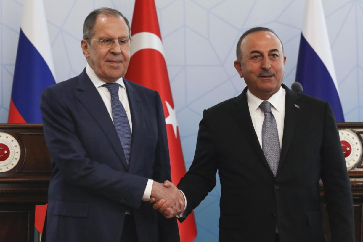 Russian Foreign Minister Sergey Lavrov, left, and Turkish Foreign Minister Mevlut Cavusoglu shake hands at the end of a joint news conference in Ankara, Wednesday, June 8, 2022.