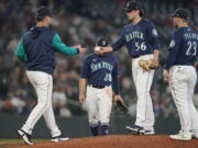 Seattle Mariners relief pitcher Penn Murfee (56) is pulled by manager Scott Servais, left, during the eighth inning of the team's baseball game against the Minnesota Twins, Wednesday, June 15, 2022, in Seattle. (AP Photo/Ted S.