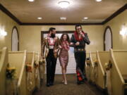 Elvis impersonator Brendan Paul, right, walks down the aisle during a wedding ceremony for Katie Salvatore, center, and Eric Wheeler at the Graceland Wedding Chapel in Las Vegas.